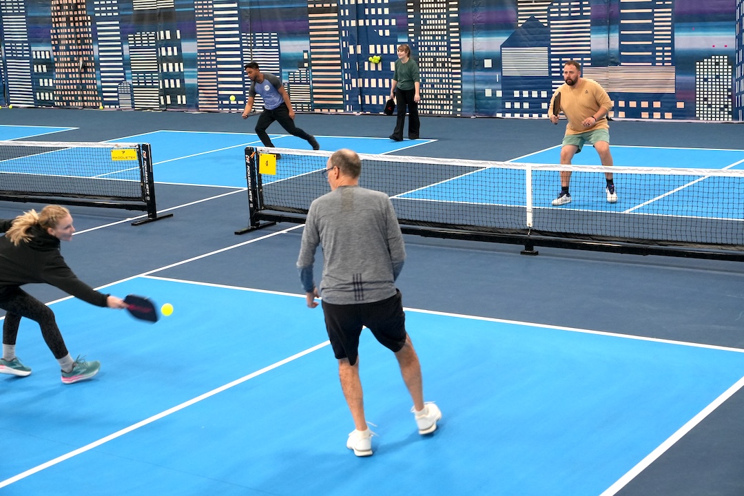 goshen-pickleball-courts pickleball players diving at the pickleball during a game